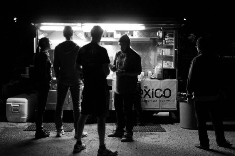 people standing in front of a taco stall (in black and white)